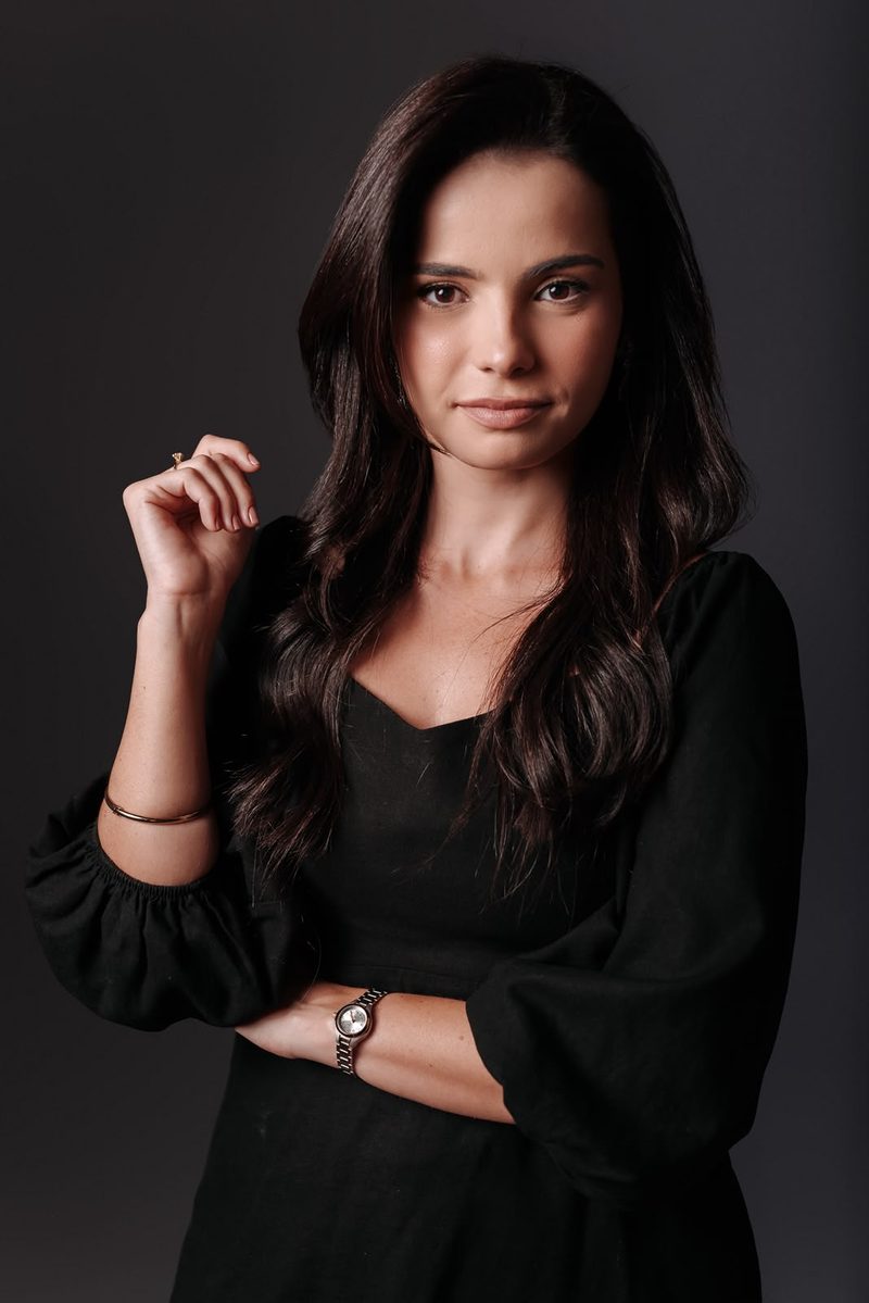 Wagna Soares Souza Lima, advogada civil e empresarial, em retrato de meio corpo com vestido preto.